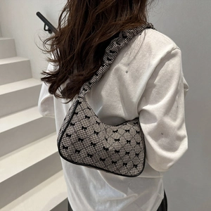 Chic black and white quilted shoulder bag with bow details and ruffled strap design