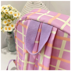 Détail du sac à dos en nylon à carreaux violets avec poignée tissée et coutures solides