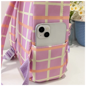 Détail d'un sac à dos d'école à carreaux roses montrant une poche latérale de rangement