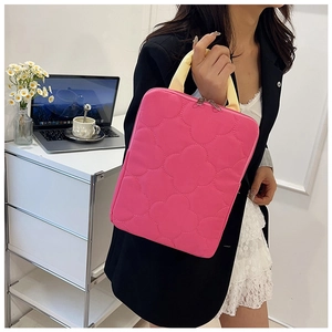 Detail of rose pink clover quilted laptop bag with pale yellow handles and silver zippers