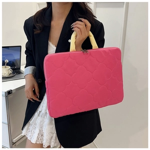 Pink quilted laptop bag with yellow handles shown in a modern office scene for professional use