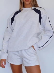 Detail of grey crewneck sweatshirt featuring blue contrast shoulder piping and soft cotton texture