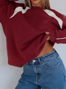 Loose fit burgundy sweatshirt with white shoulder panels shown on a female model