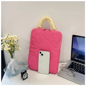 Pink quilted laptop sleeve with yellow handles and size comparison to a smartphone