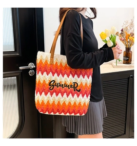 Detail der bunten Strohtasche mit Wellenmuster, Lederriemen und SUMMER-Stickerei