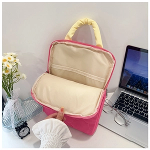 Detail of rose pink quilted iPad sleeve showing interior elastic strap and yellow handles