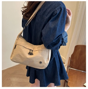 Détail du sac bandoulière en nylon kaki avec grande poche et tirettes doubles triangles