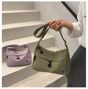 Détail des sacs bandoulière en nylon vert et violet avec doubles zips et logos