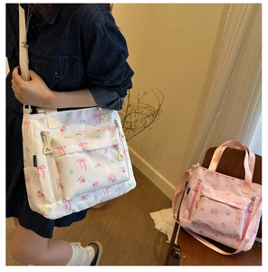 Detail of floral canvas tote bag showing bow patterns and functional zippered pockets