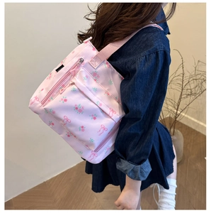 Pink tote bag detail with rose patterns and bow prints on durable nylon fabric