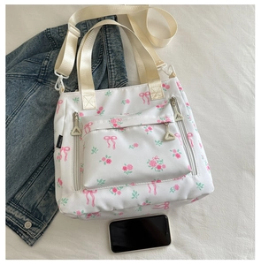 Detail of floral tote bag showing pink rose print and functional zipper pockets
