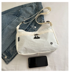 Detail of white nylon tote bag with crinkled texture, double zippers and wide strap