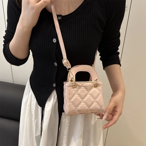 Mini pink quilted crossbody bag with gold hardware and top handle shown on model