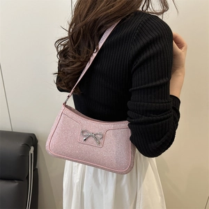 Borsa sottobraccio con paillettes rosa e fiocco argento mostrata su modella di lato