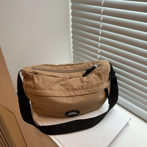 Close-up of a light brown crescent nylon bag with a Lucky Fashion logo badge