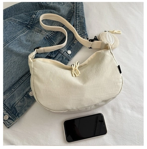 Detalle del bolso media luna de lona crema con correa ajustable y pequeño monedero
