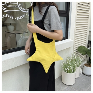 Vista street style di una borsa a tracolla a forma di stella in tela giallo vivace