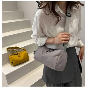 Détail du sac bandoulière en nylon avec bandoulière réglable et étiquette de marque