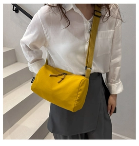 Détail d'un sac bandoulière en nylon jaune vif avec fermeture éclair et bandoulière
