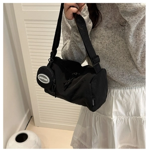 Dettaglio borsa a tracolla cilindrica in nylon nero con mini borsellino tondo abbinato
