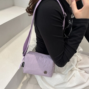 Borsa a tracolla in nylon viola lavanda impermeabile per sport e fitness indossata dal modello