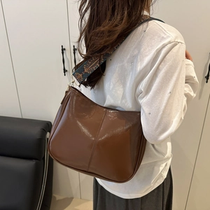 Deep brown semi-glossy shoulder bag with ethnic patterned strap for daily commute