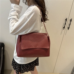 Deep red woven crossbody bag with gold chain strap and elegant flap closure design