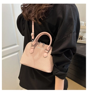 Detail of pink woven texture crossbody bag with double handles and silver hardware