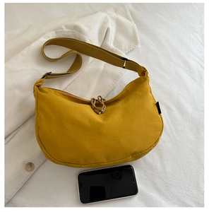 Ginger yellow nylon crescent bag shown with a smartphone for scale comparison