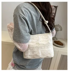 Detail of white lace tote bag with ruffle texture and knotted shoulder strap detail
