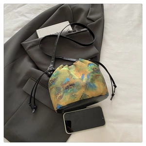 Detail of drawstring bucket phone bag with vintage landscape print and leather strap