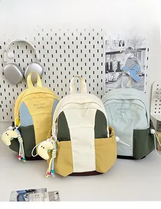 Detailed view of mini contrast-color canvas backpacks with embroidery and plush moon charms