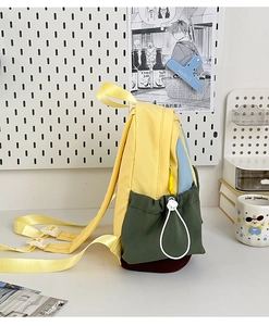 Detail of color block mini canvas backpack featuring yellow, blue and green panels