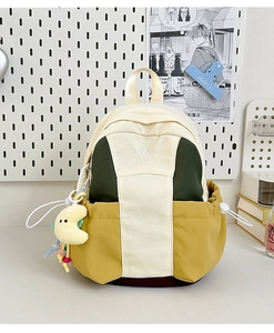 Detail of color-block canvas backpack with embroidery and cute moon plush pendant