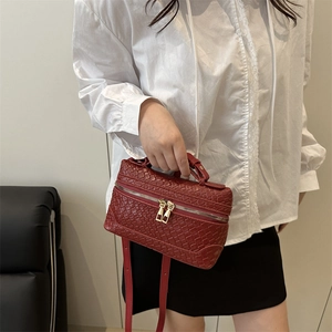 Red woven leather handbag with top handle and gold zipper shown on a female model