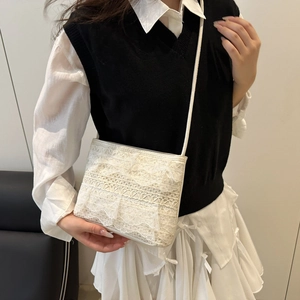 Borsa a spalla in pizzo avorio con trama a onde plissettate indossata da una modella