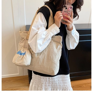 Dettaglio borsa tote beige in velluto a coste con ricamo Beach sulla mini tasca