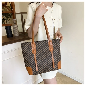 Detailed view of the large capacity tote bag featuring geometric patterns and brown leather straps