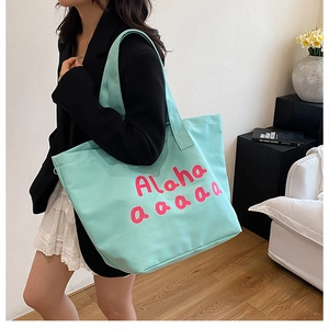 Detailed view of mint green canvas tote bag with pink Aloha printed design