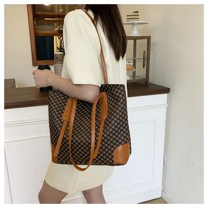 Close-up of stylish large tote bag with geometric patterns and brown leather straps
