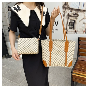 Close-up of printed tote bag and small crossbody bag set with brown leather straps
