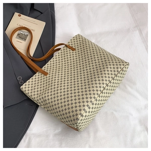 Detail of large tote bag with geometric patterns, leather handles and office suit backdrop