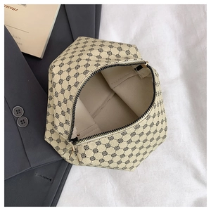 Detailed close-up of clover pattern storage bag with gold zipper on sleek office props