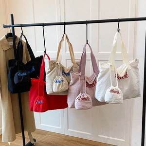 Borse tote estive in tela con ricamo Beach in cinque colori appese a grucce