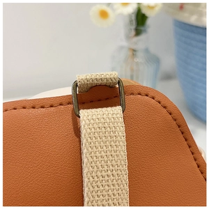 Détail d'un sac bandoulière en cuir avec boucle en bronze vintage et finitions de couture