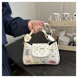 Detail of white polka dot bag with colorful patches and woven handle for summer