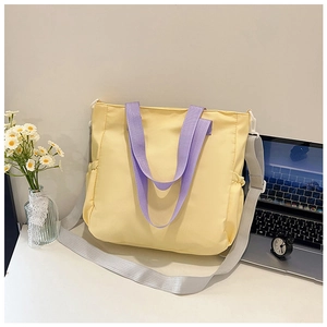 Dettaglio della grande borsa tote con manici viola e tracolla grigia regolabile