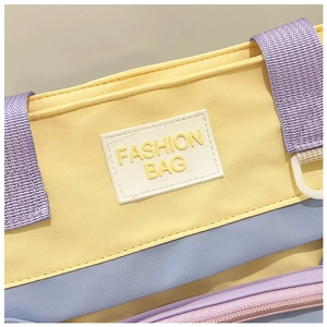 Detail shot of multi-color canvas bag showing the Fashion Bag patch and precise stitching