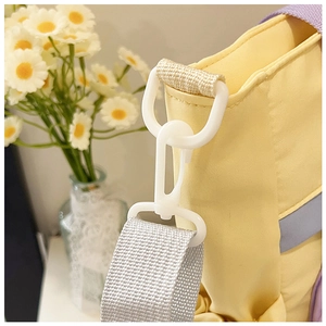 Close-up of white plastic hardware and nylon straps on a yellow Harajuku style tote bag