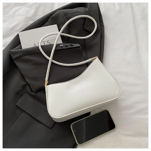 Vue détaillée d'un sac demi-lune blanc montrant la capacité intérieure avec un téléphone